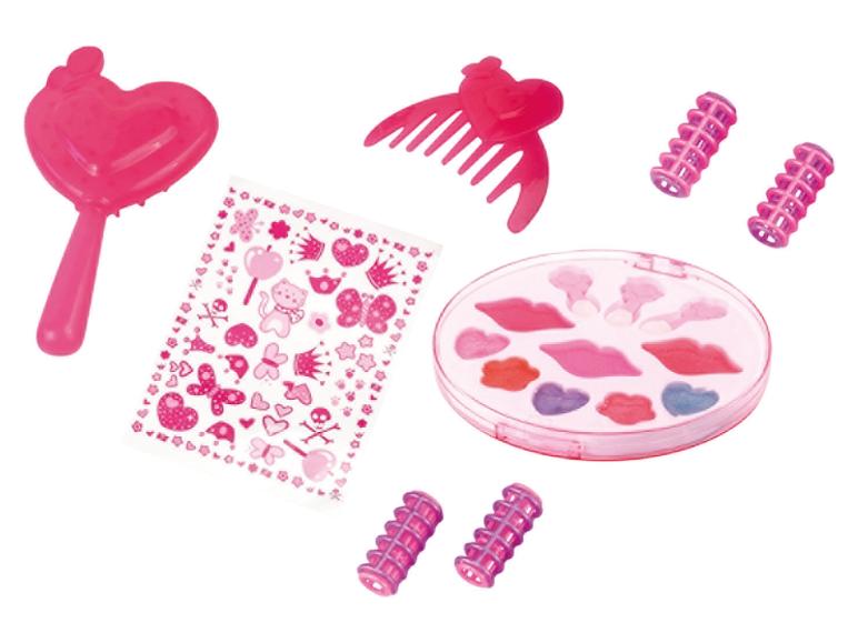 Kit de maquillage jouet rose avec baguette en forme de cœur, peigne, bigoudis, autocollants et palette de gloss.