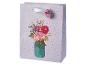 Sac cadeau violet à pois avec un bouquet de fleurs dans un pot, avec une étiquette florale.
