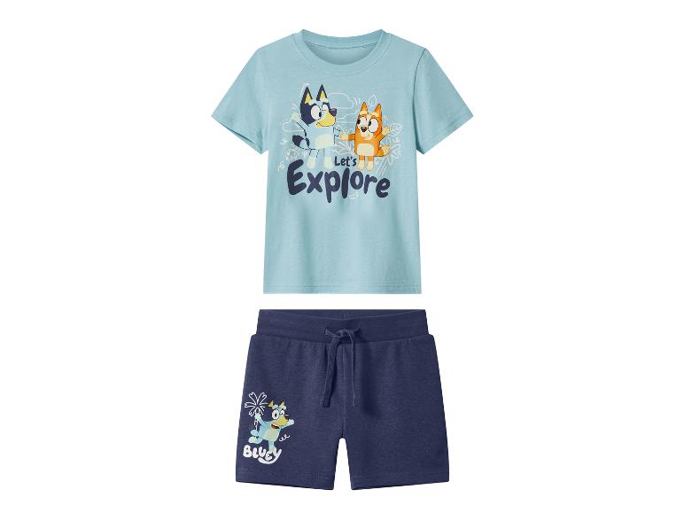 Ensemble enfant avec t-shirt bleu clair et short bleu foncé, tous deux avec des imprimés de personnages de dessins animés.