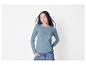 Femme en pull bleu clair et jeans.