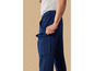 Un homme portant un pantalon cargo bleu avec une poche zippée.