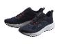 Une paire de chaussures de course bleu foncé avec laçage orange et semelles blanches.