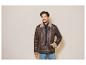 Man in een bruin leren jack met bontvoering