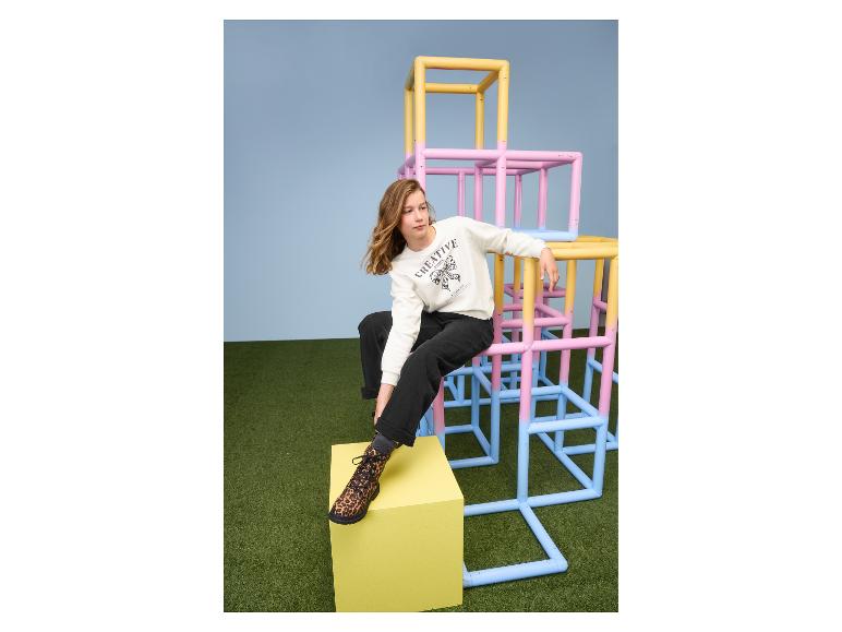 Un enfant portant des chaussettes ESMARA KIDS, assis sur une cage à poules colorée.