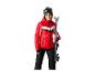 Vrouw in rode ski-jas en zwarte skibroek houdt ski's vast.