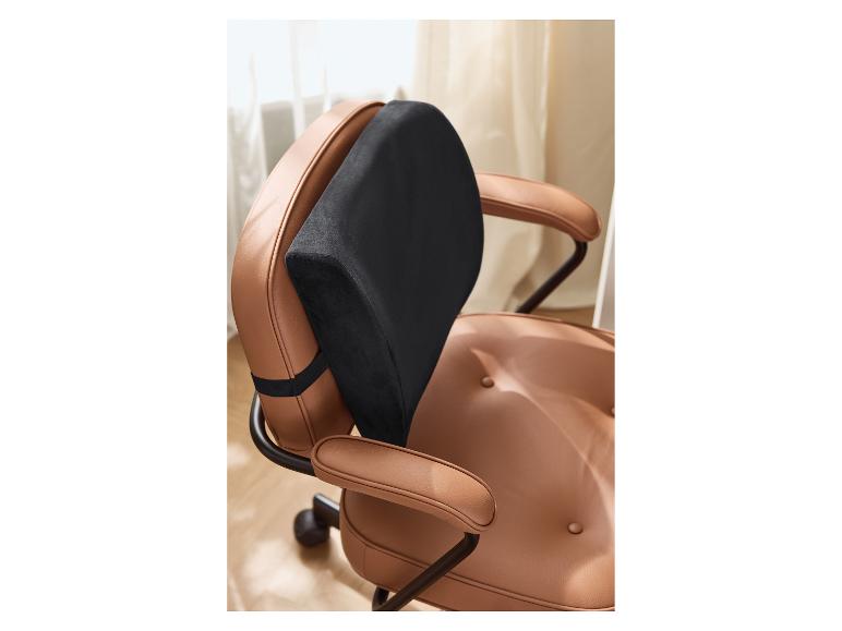 Coussin lombaire noir sur une chaise de bureau en cuir marron clair.