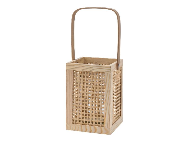Een houten lantaarn met een handvat en een gevlochten patroon.