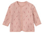 Une grenouillère rose pour bébé avec un motif de girafes.