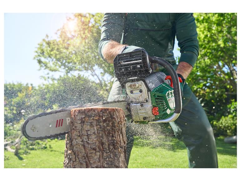 Een man zaagt hout met een groene Park-kettingzaag.