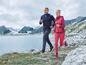 Deux personnes courent en tenue de sport dans un paysage montagneux.