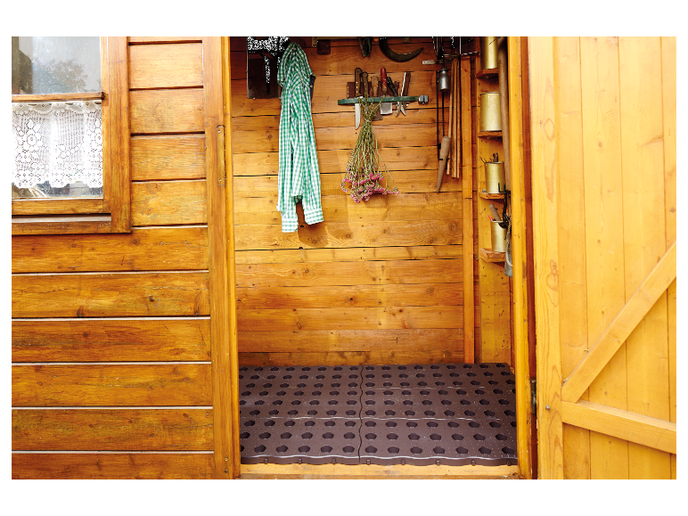Rangement de jardin en bois : outils, tapis de sol et vêtements.