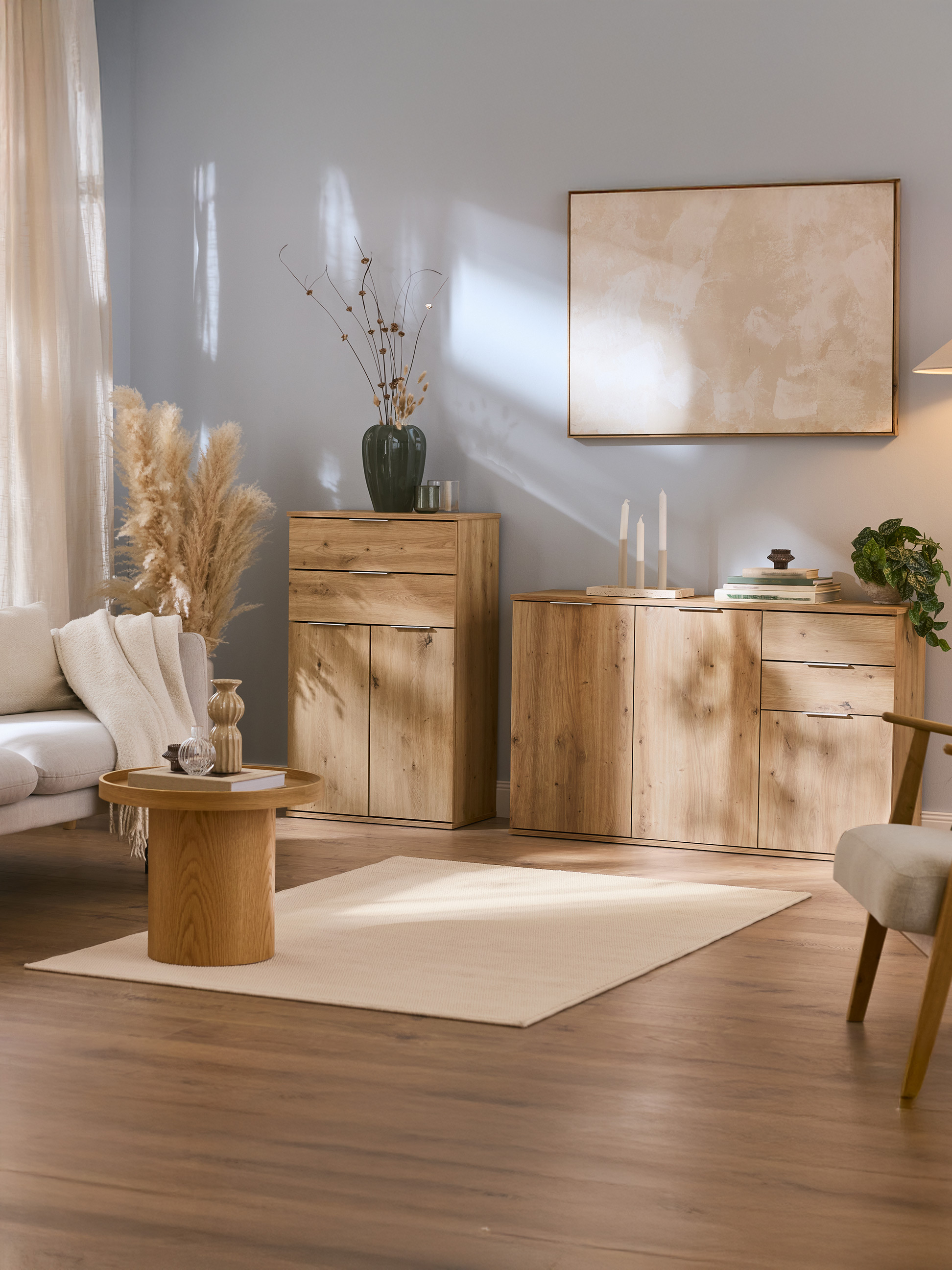 Salon avec armoires en bois, canapé, table basse et décor aux tons neutres.