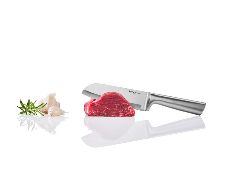 Un couteau Livarno Home, un morceau de viande, de l'ail et du romarin.