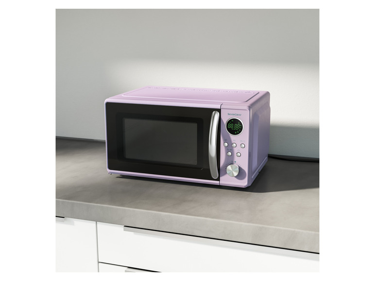 Un four à micro-ondes SilverCrest violet sur un comptoir.