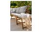 Banc de jardin en bois avec coussins gris et plaid rayé sur une terrasse