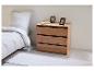 Commode trois tiroirs en bois clair avec détails noirs, dans une chambre.