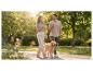 Couple promenant un golden retriever dans un parc, profitant du soleil.