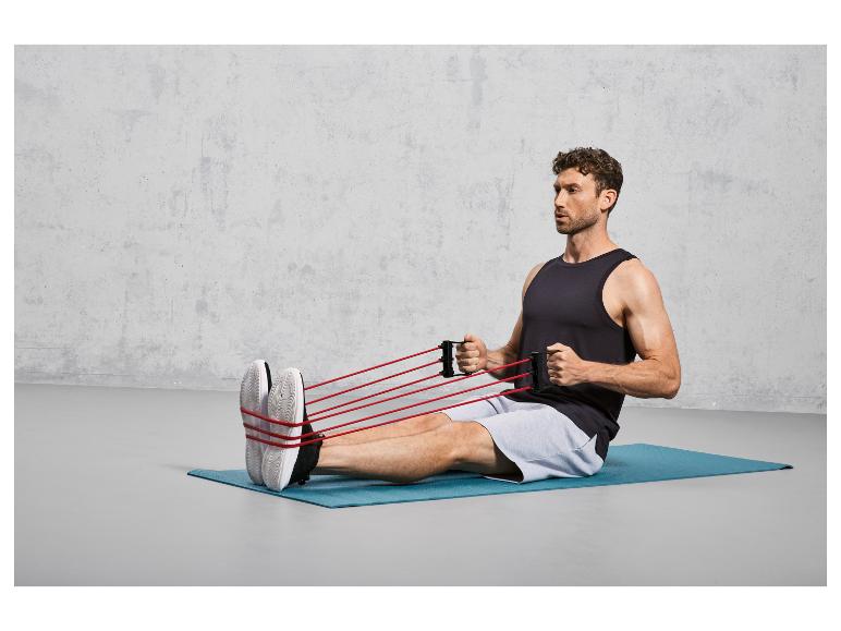 Een man die met weerstandsbanden traint op een yogamat.