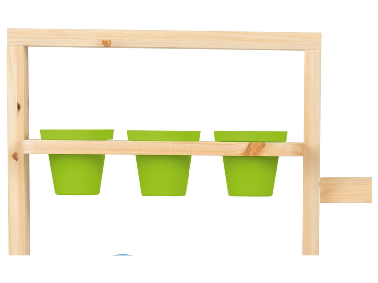Trois pots verts suspendus à une étagère en bois.