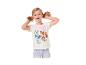 Lachend blond meisje met staartjes, draagt een wit Paw Patrol T-shirt en jeans.