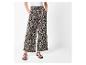 Wijde broek met luipaardprint en eenvoudige zwarte sandalen.
