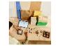 Enfant jouant avec des blocs de construction et une tablette sur une table en bois.