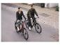 Twee mensen fietsen op elektrische fietsen door de stad.