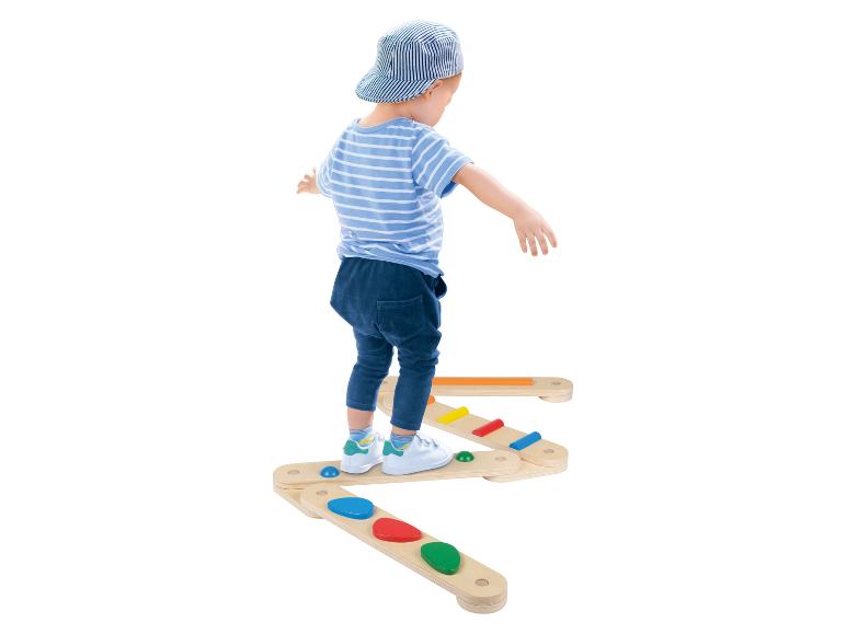 Een kind speelt met houten speelgoed voor evenwicht.