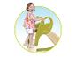 Enfant souriant grimpant sur un toboggan vert.