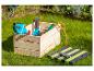 Tuingereedschap in een houten kist op groen gras.