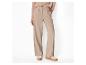 Pantalon large beige taille haute et pull rose pâle, associés à des baskets à semelle épaisse.