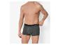 Un homme torse nu porte un boxer gris avec une ceinture noire.