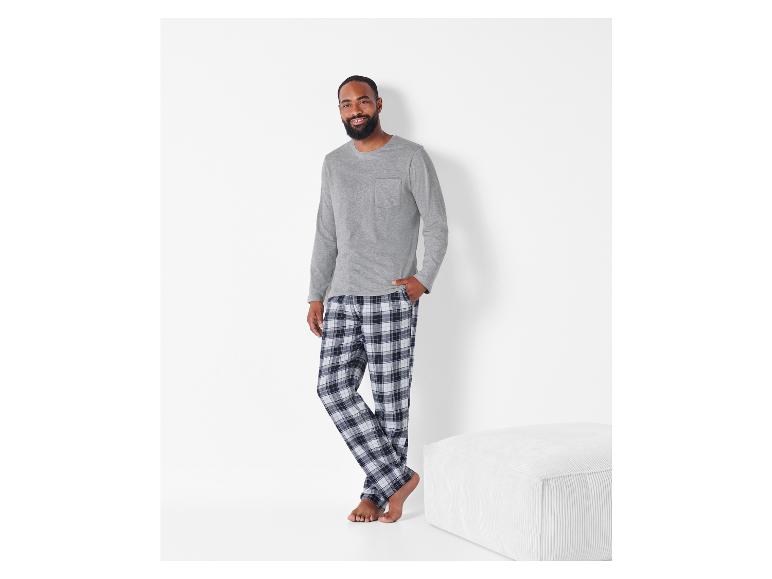 Man in grijze longsleeve en geruite pyjamabroek.