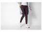 Femme en cardigan gris tricoté, haut blanc et leggings foncés avec baskets.