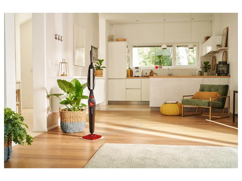 Balai vapeur dans un salon moderne avec parquet et plantes.
