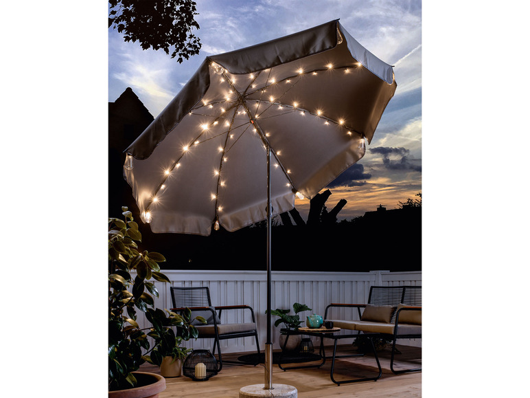 Een grijze parasol met ingebouwde verlichting voor buiten, met twee stoelen en een salontafel.