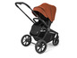 Een zwarte kinderwagen met een bruin zonnekapje.