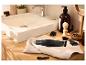 Tondeuse à cheveux et accessoires sur une serviette dans une salle de bain avec lavabo.