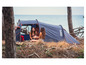 Twee vrouwen zitten in een Tambu-tent aan de kust.