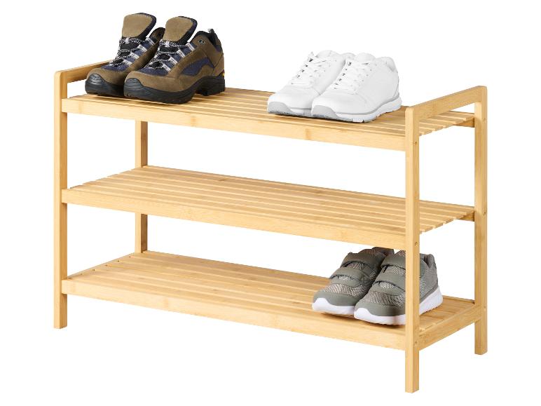 Étagère à chaussures en bois avec bottes de randonnée, baskets blanches et chaussures pour enfants grises.