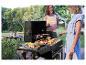 Buiten barbecue: worstjes, spiesjes en kip op een zwarte grill.