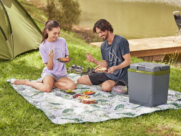 Een koeler, een picknickdeken en een stelletje genieten van hun lunch in de buitenlucht.