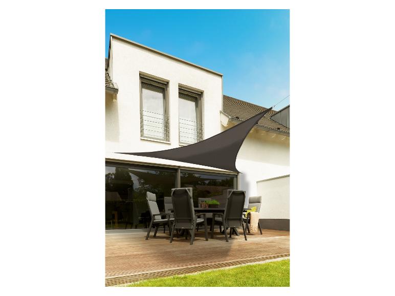 Terras met houten vloer, tuinmeubelen en een bruin schaduwdoek.