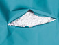 Een turquoise kussen met een open rits, gevuld met witte EPS-parels.