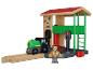 Houten speelgoedset met trein, station en figuur op witte achtergrond.