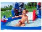 Blij jongetje speelt in opblaasbaar kinderzwembad met waterspeelgoed.