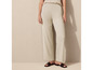 Pantalon beige à jambes larges et sandales noires.