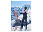 Vrouw in roze en marineblauwe ski-jas en broek, met ski's en stokken in de sneeuw.
