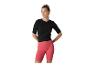 Vrouw in zwart T-shirt en koraalkleurige fietsbroek