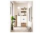 Meuble d'entrée avec meuble à chaussures, étagères et miroir blanc et bois, plantes et décorations.